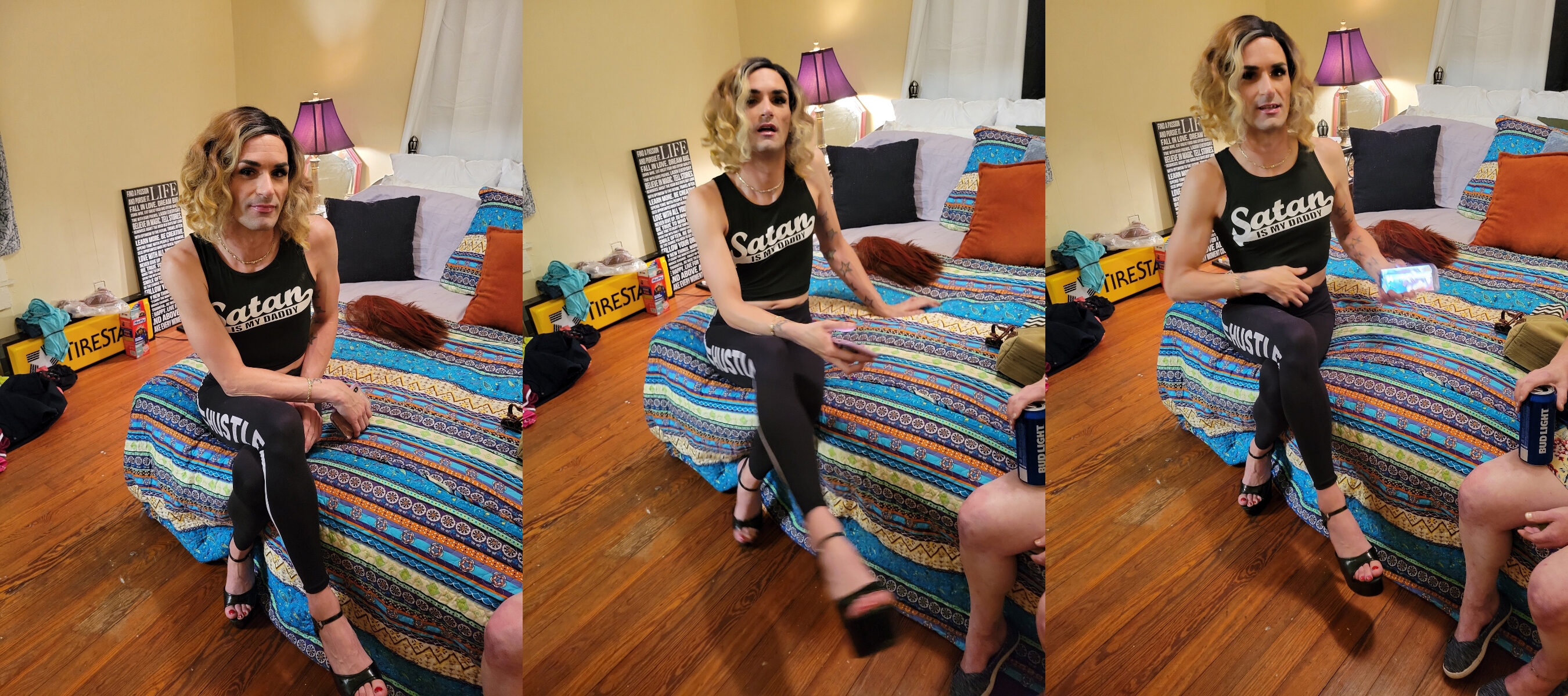 Hank, the cross dressing satanic cultist, dressed as a girl and wearing makeup, sporting a 5 o clock shadow, and wearing a shirt that says satan is my daddy. His clothes are all black, skimpy, and showing skin, as he is holding his cell phone, and there is a can of bud light creeping into in the side view of the photo.